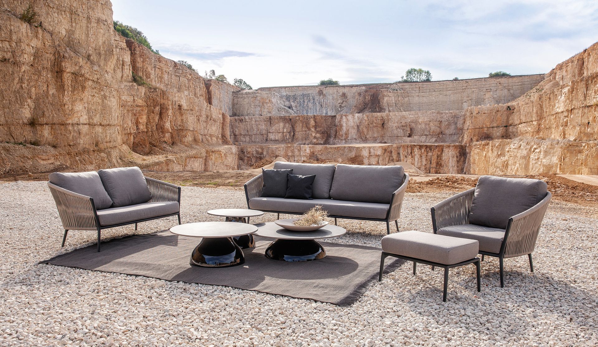 Exklusive Cosmo Lounge-Gruppe von Fischer Möbel vor einer beeindruckenden Felskulisse. Hochwertige Outdoor-Sofas mit markanter Seilflechtung für luxuriöses Design im Freien.