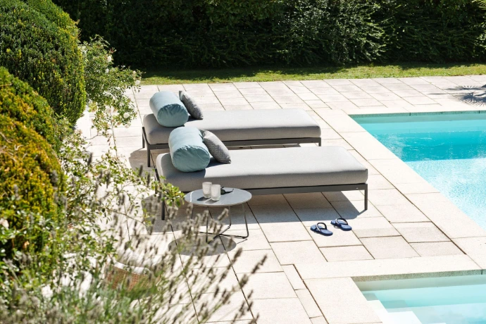 Elegante Sonnenliegen von Fischer Möbel auf moderner Poolterrasse mit Beistelltisch